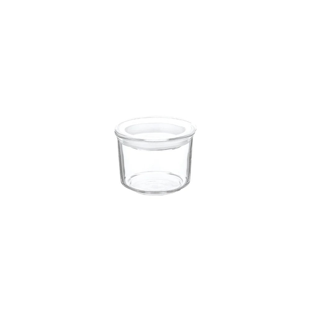 Clear glass container with a white lid on a white background