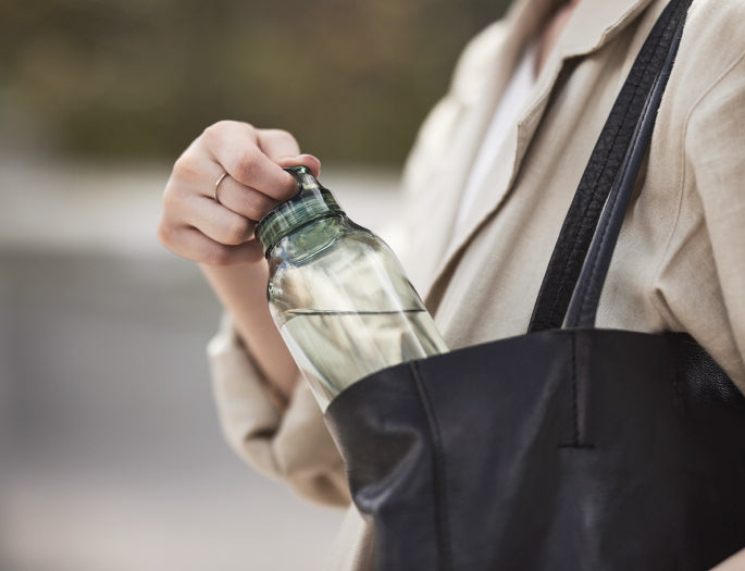 Person holding a water bottle with a blurred background